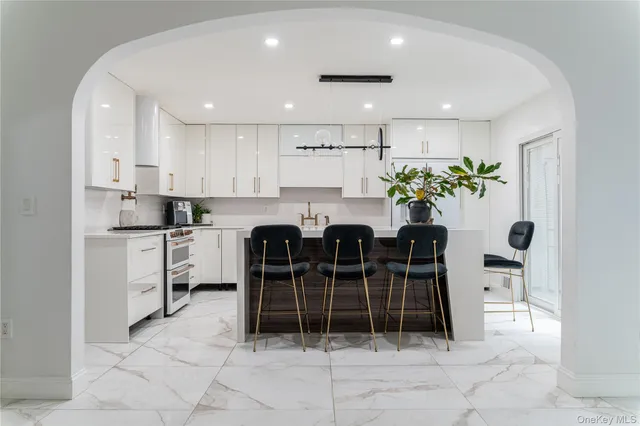a kitchen with stainless steel appliances kitchen island granite countertop a table and chairs in it