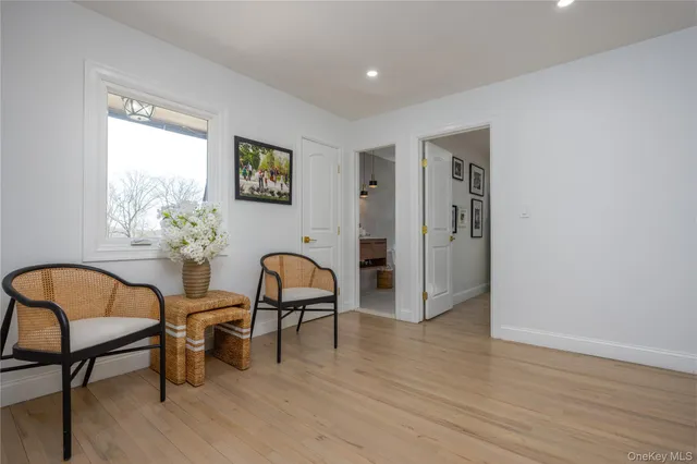 a view of a workspace room with wooden floor and furniture