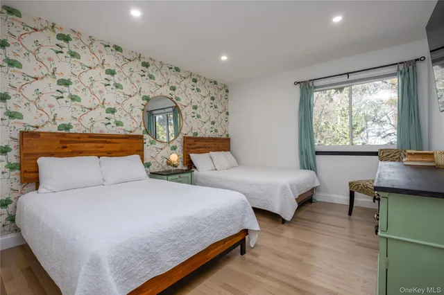 a bedroom with two beds and a large window