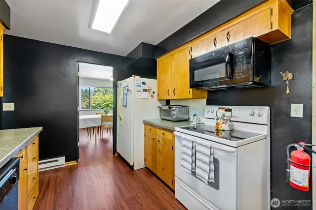 a kitchen with stainless steel appliances granite countertop a stove a sink and wooden cabinets