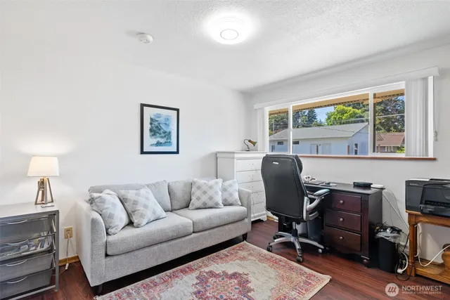 a view of a workspace with wooden floor and windows