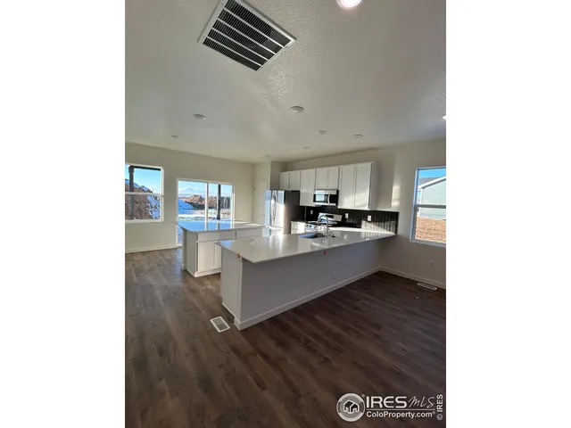 a kitchen with stainless steel appliances kitchen island granite countertop a refrigerator and a stove top oven