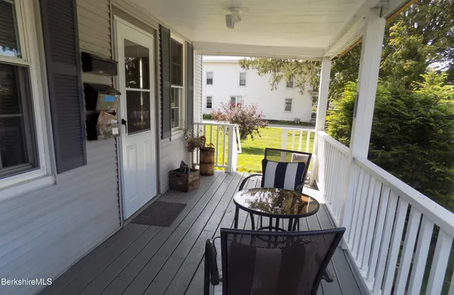 a view of a house with a big yard and large trees