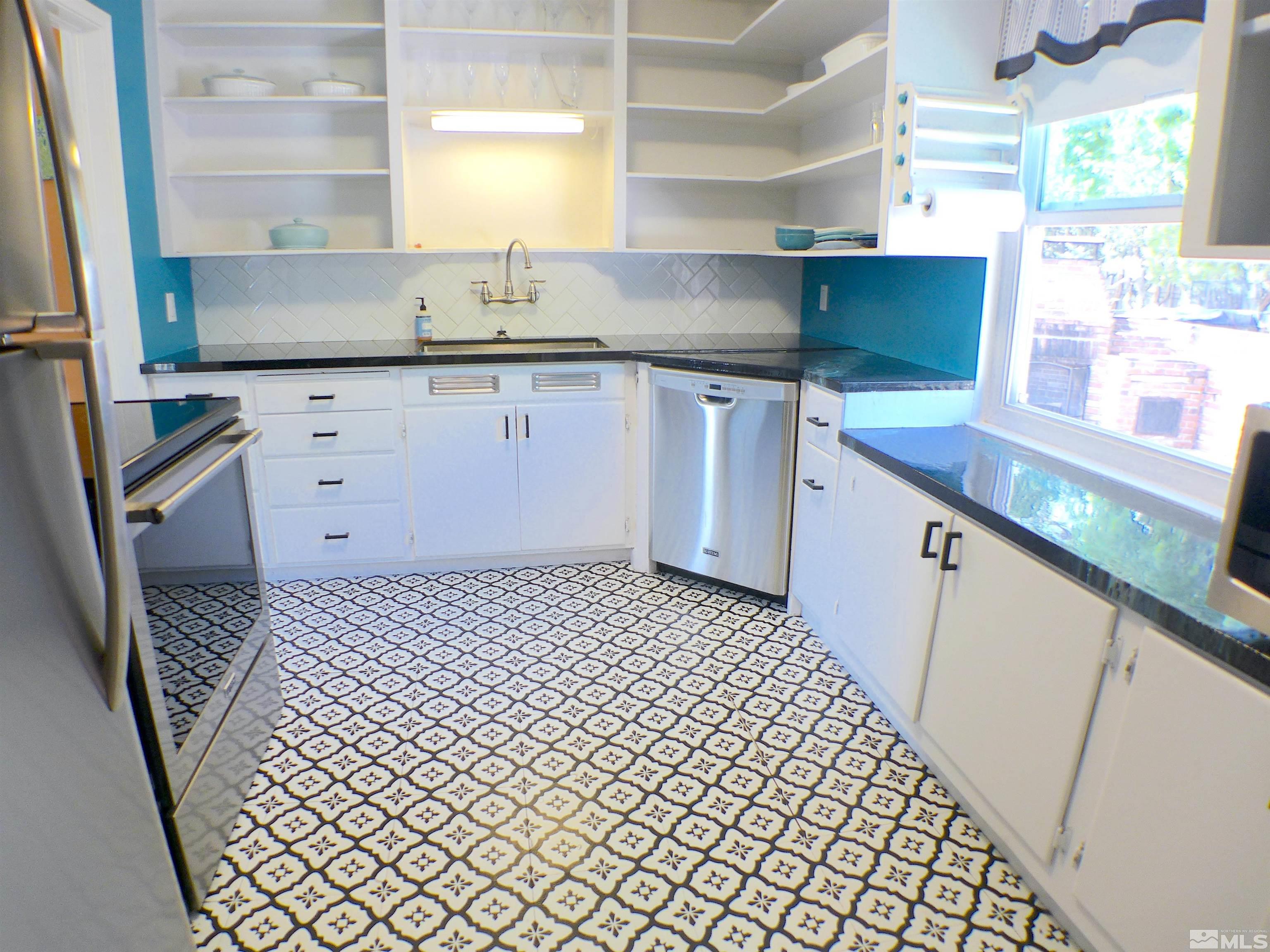 925 Yori Avenue Reno, NV 89502 - Photo 7 of 20 a kitchen with a sink a stove wooden floor and cabinets