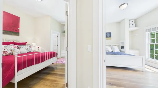 a living room with stainless steel appliances furniture a flat screen tv and kitchen view