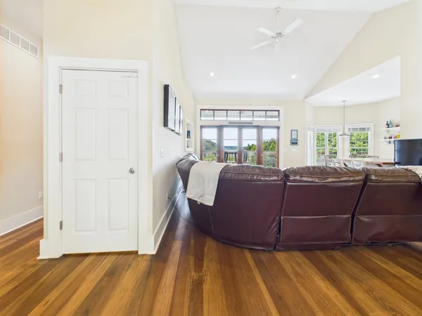 a living room with furniture a flat screen tv and a floor to ceiling window
