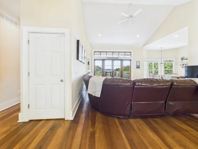 a living room with furniture a flat screen tv and a floor to ceiling window