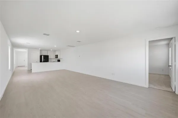 a view of a big room with wooden floor and windows