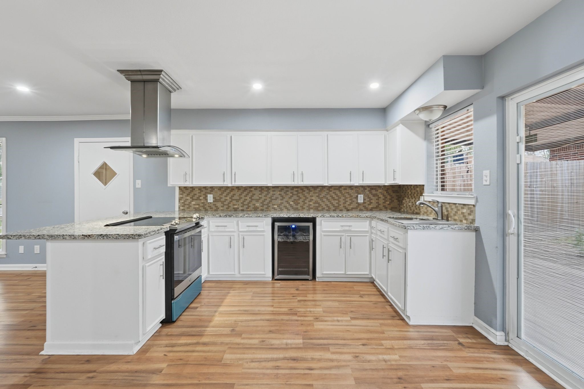 20 Moon Valley Court Conroe, TX 77304 - Photo 14 of 32 a kitchen with granite countertop a stove top oven sink and cabinets