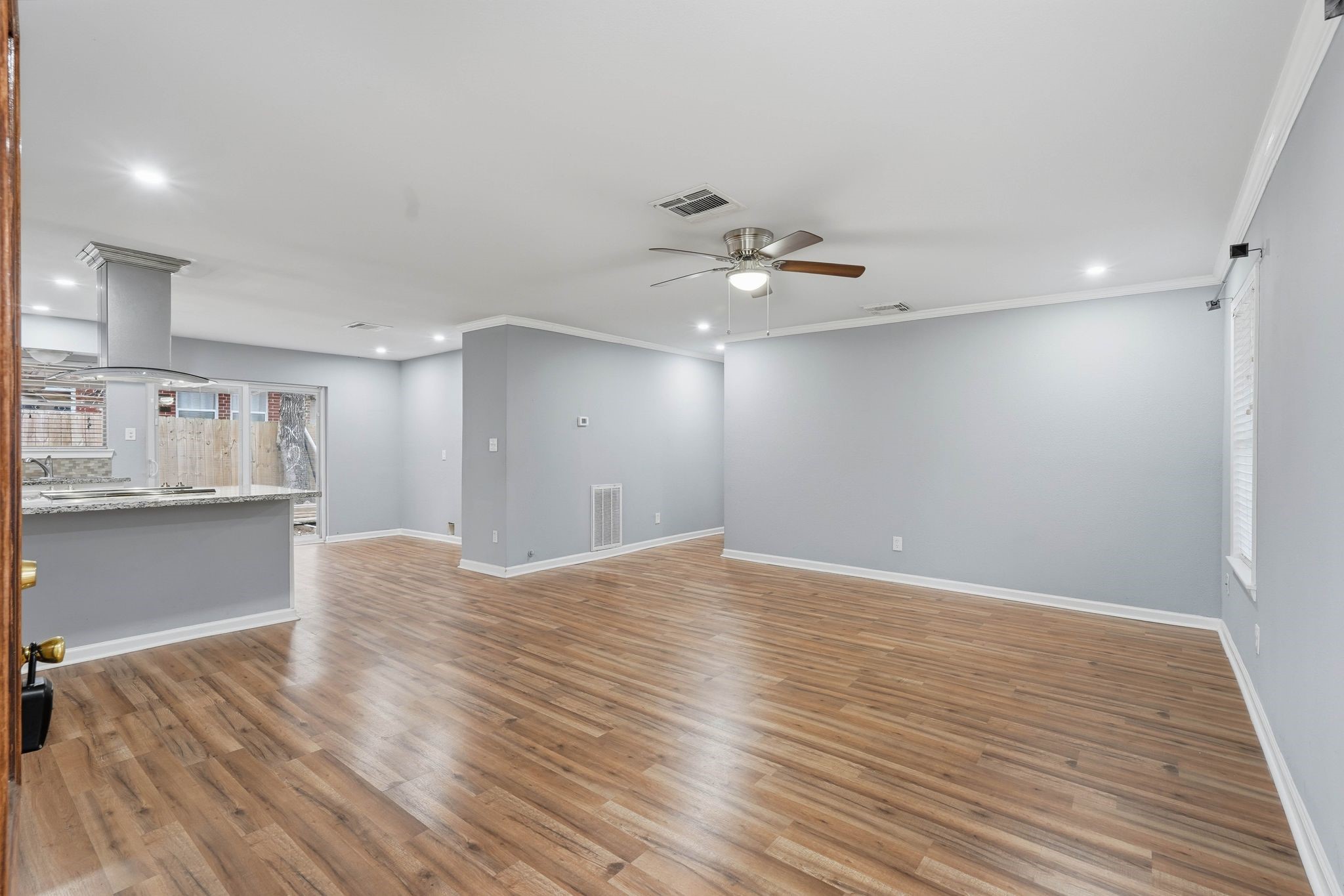 20 Moon Valley Court Conroe, TX 77304 - Photo 7 of 32 a view of kitchen and empty room with wooden floor