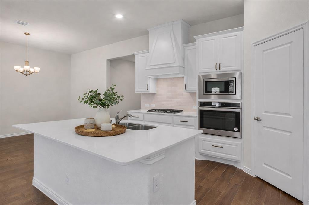 3106 Maverick Drive Forney, TX 75126 - Photo 11 of 32 a kitchen with a white stove top oven and white cabinets