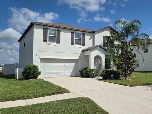 a front view of a house with a yard and garage