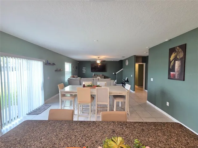 a kitchen with granite countertop a refrigerator and a stove top oven