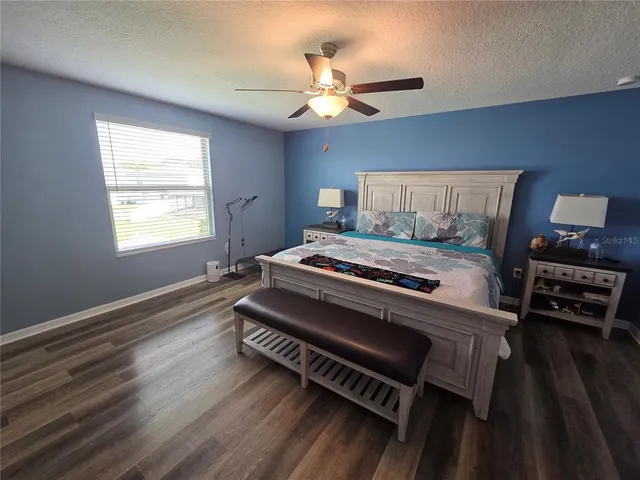 a bedroom with a bed and a flat tv screen on dresser