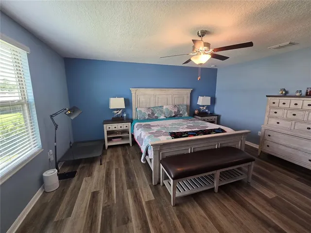 a spacious bathroom with a granite countertop sink a mirror and shower