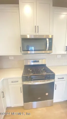 a view of a kitchen with kitchen island a sink wooden floor and a counter top space