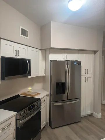 a kitchen with refrigerator and microwave