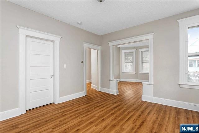 20 Dankoff Avenue, Unit 1 Wallington, NJ 07057 - Photo 3 of 15 wooden floor in an empty room with a window