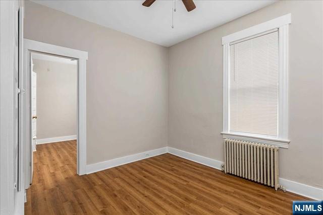 20 Dankoff Avenue, Unit 1 Wallington, NJ 07057 - Photo 10 of 15 an empty room with wooden floor and windows