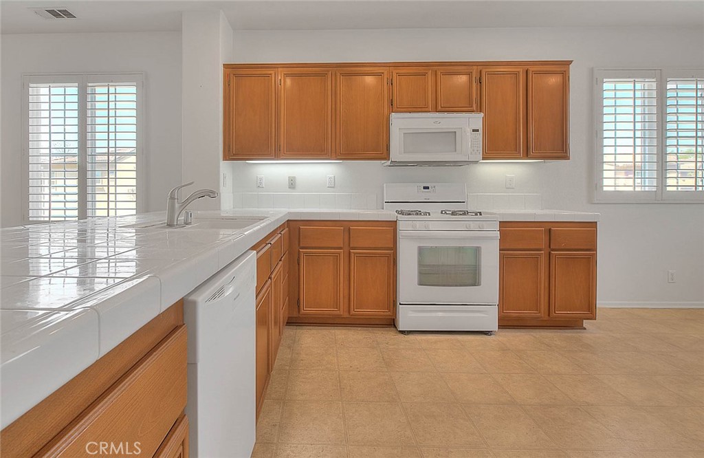 8150 West Preserve Loop Chino, CA 91708 - Photo 20 of 51 a kitchen with stainless steel appliances granite countertop a stove a sink and a microwave