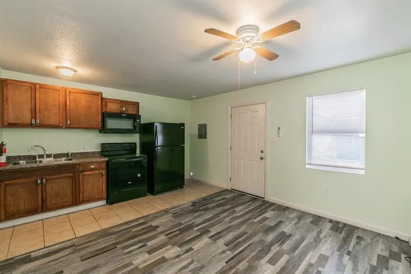 a kitchen with stainless steel appliances granite countertop a stove a refrigerator and a cabinets with wooden floor
