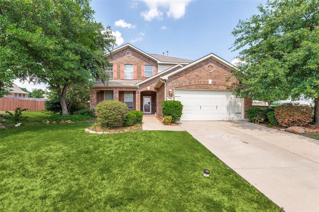 a front view of a house with a yard and trees