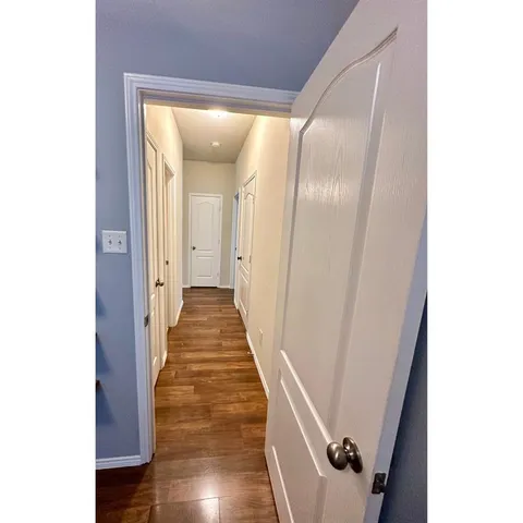 a view of a hallway with wooden floor
