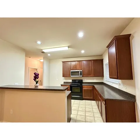 a kitchen with kitchen island a stove a sink and a microwave