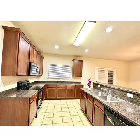 a kitchen with a sink a counter top space and appliances