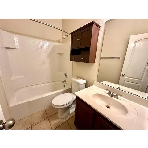 a bathroom with a sink a toilet a mirror and bathtub