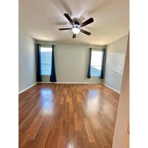 a view of empty room with wooden floor