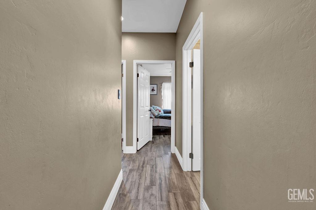 Undisclosed Address Bakersfield, CA 93307 - Photo 19 of 30 a view of a hallway with wooden floor and a bathroom
