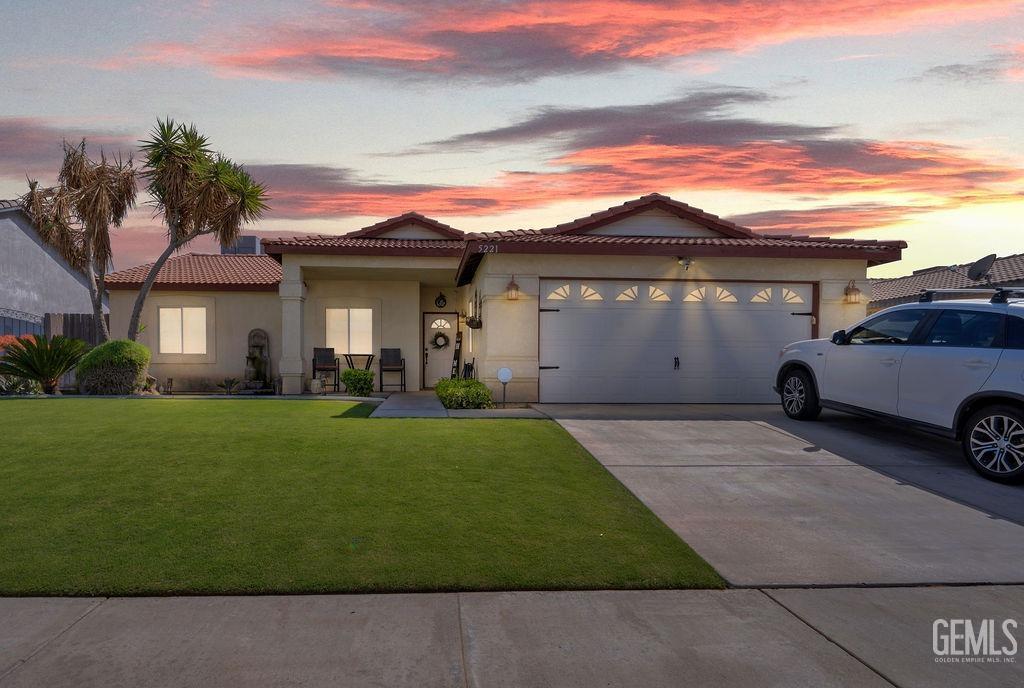 Undisclosed Address Bakersfield, CA 93307 - Photo 2 of 30 a front view of a house with a garden and a yard
