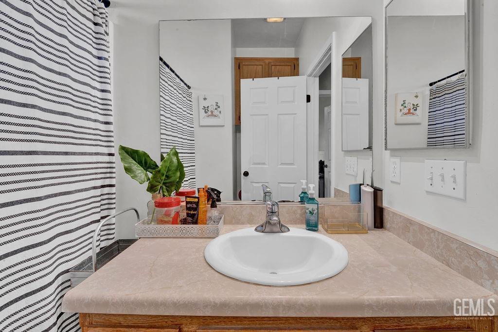 Undisclosed Address Bakersfield, CA 93307 - Photo 25 of 30 a bathroom with a sink and a mirror