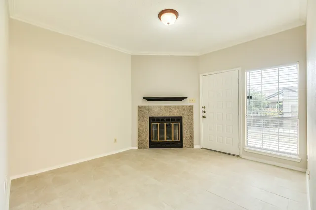 a view of an empty room with a fireplace and a window