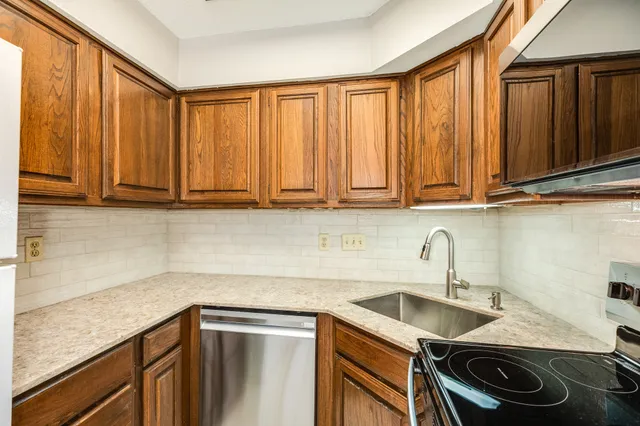 a kitchen with stainless steel appliances granite countertop a sink a stove and a microwave
