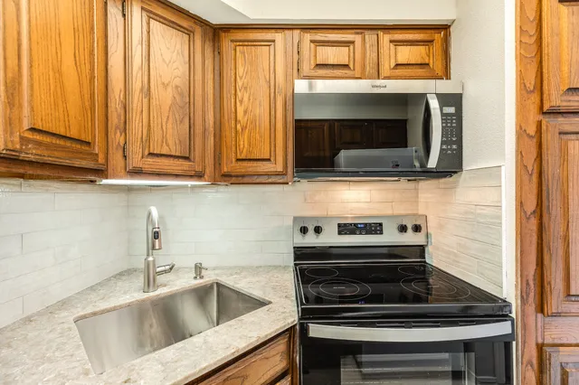 a kitchen with granite countertop a stove and a sink