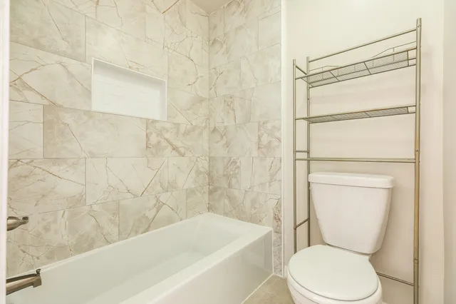 a bathroom with a toilet and a shower