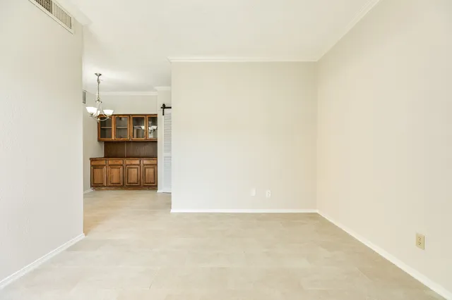 a view of a kitchen with refrigerator and more cabinets