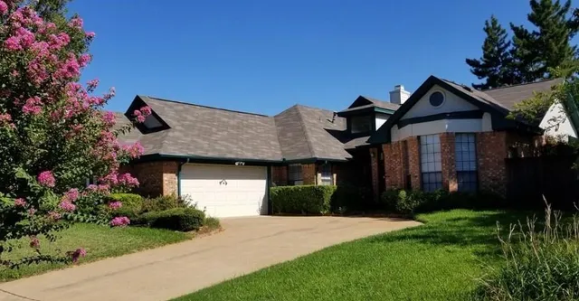 a front view of house with a garden