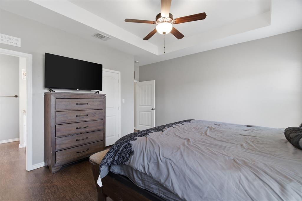 711 Hadley Lane Valley View, TX 76272 - Photo 17 of 40 Bedroom featuring a raised ceiling, ceiling fan, and dark wood-style flooring