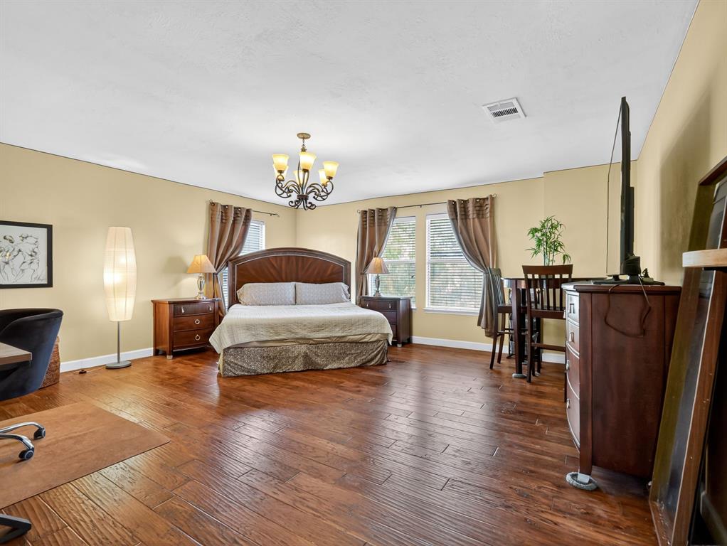 2052 Diamond Ridge Drive Carrollton, TX 75010 - Photo 31 of 40 a bedroom with a bed lamps and wooden floor