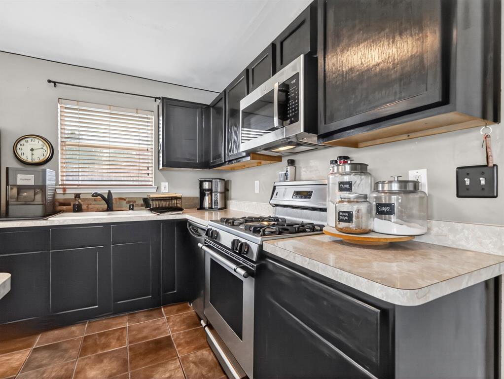 2052 Diamond Ridge Drive Carrollton, TX 75010 - Photo 35 of 40 a kitchen with granite countertop stainless steel appliances and wooden cabinets