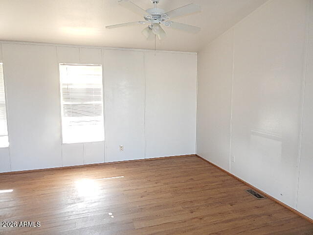 24231 West Patton Road Wittmann, AZ 85361 - Photo 4 of 12 an empty room with wooden floor and windows