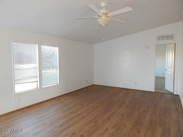 24231 West Patton Road Wittmann, AZ 85361 - Photo 8 of 12 an empty room with wooden floor fan and windows