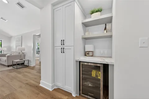 a kitchen with a sink a stove and chairs with wooden floor