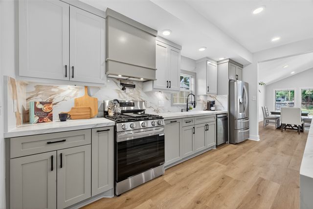 a large kitchen with kitchen island a large counter space a sink appliances and cabinets