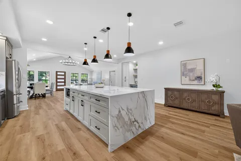 a room with lots of wooden furniture and a kitchen view