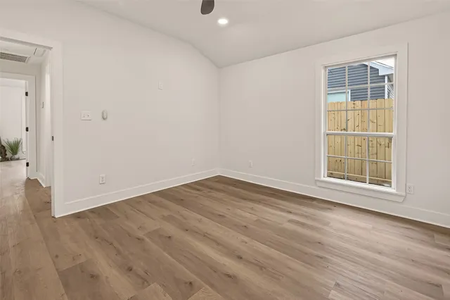 a view of an empty room with wooden floor