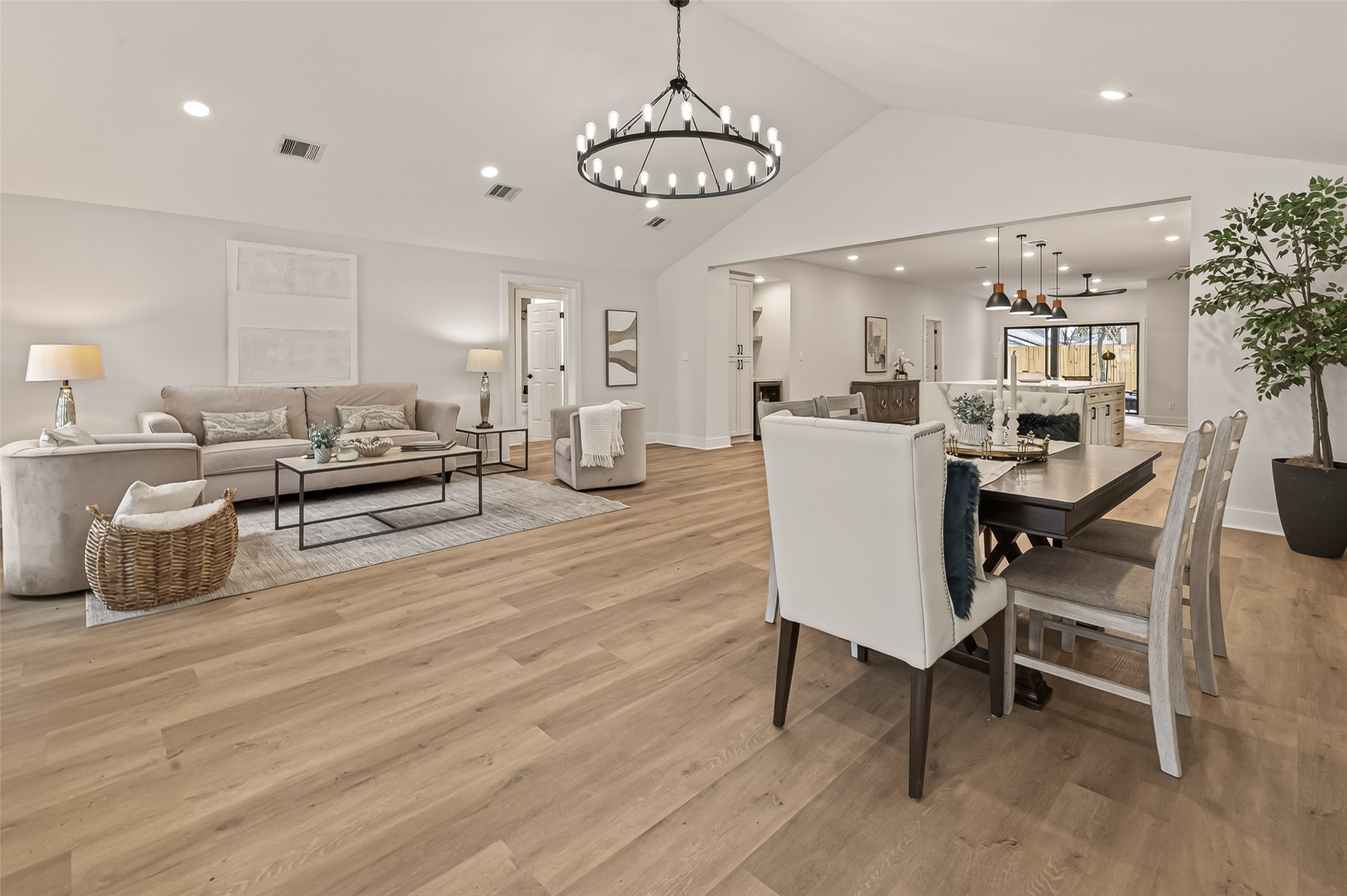 906 Eleanor Street Houston, TX 77009 - Photo 4 of 36 a dining room with wooden floor a chandelier a glass table and chairs